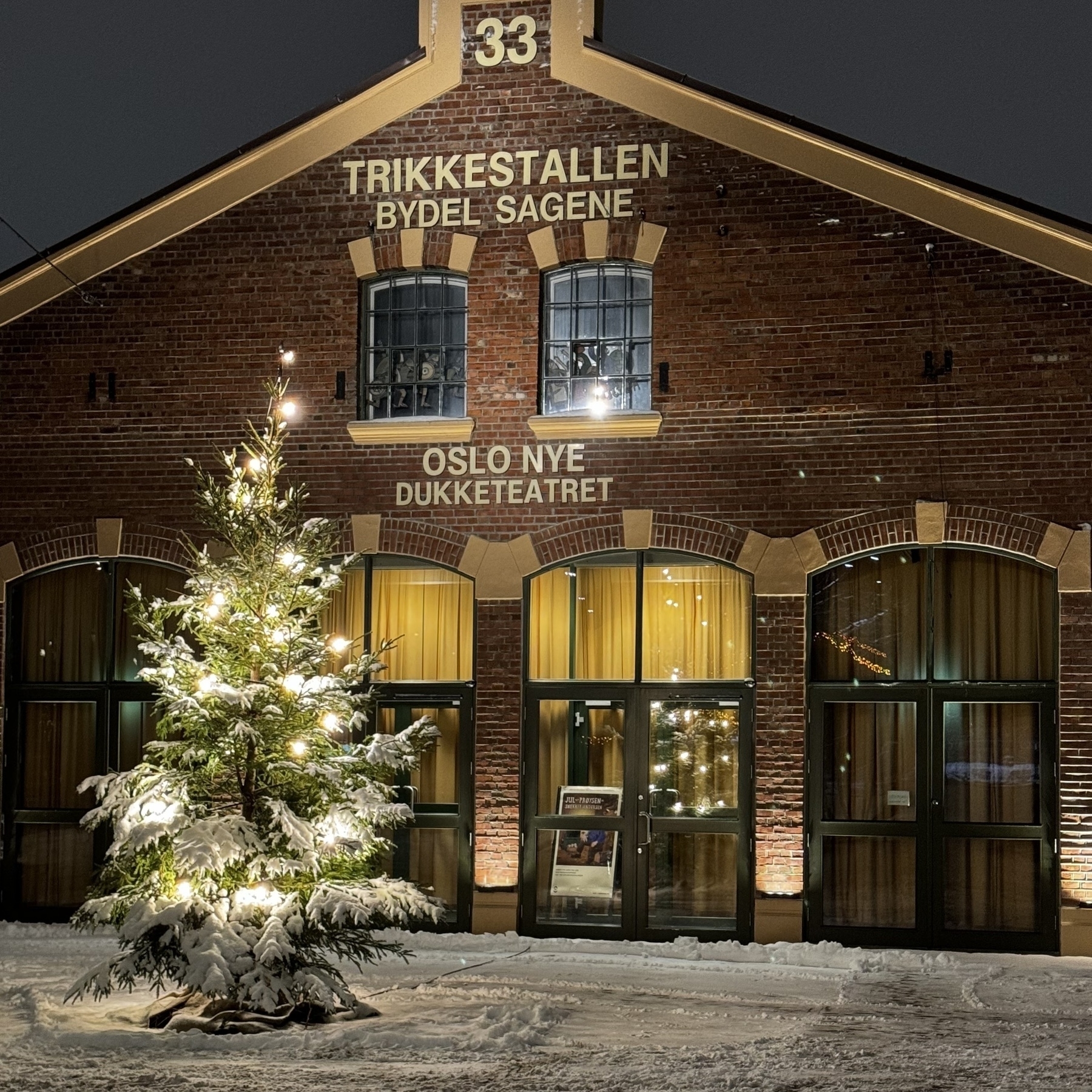 Et lyssatt juletre foran Trikkestallen på Torshov. A+ julestemning med snø på bakken. 